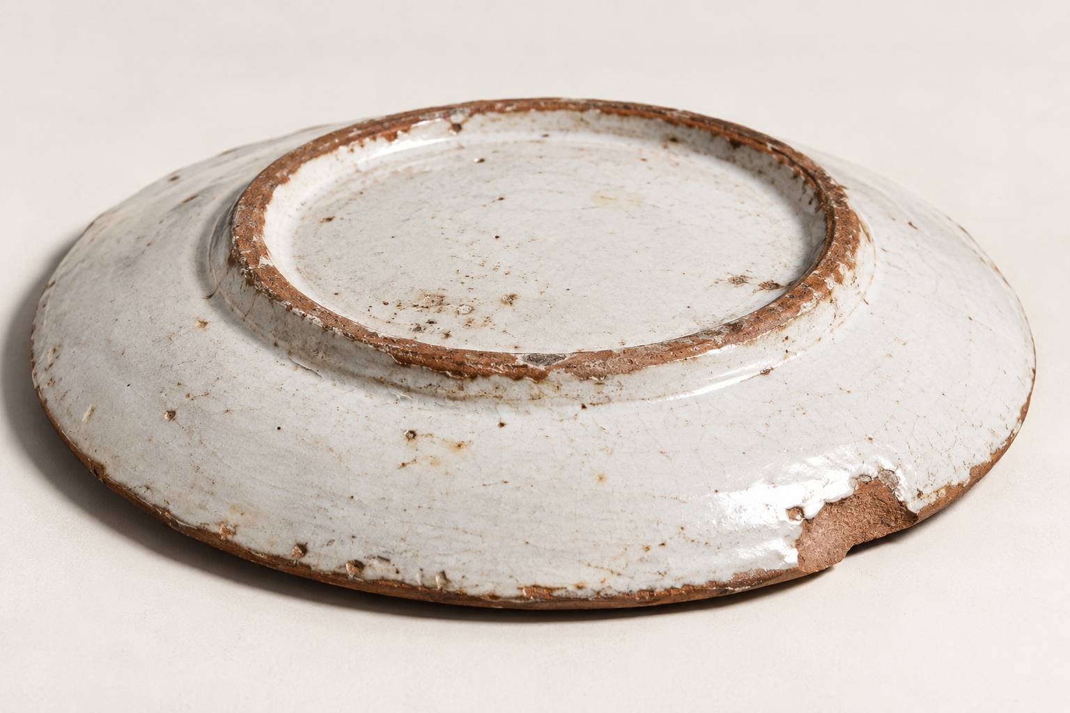 Revers non emaille d'une assiette en faience montrant la pate ocre